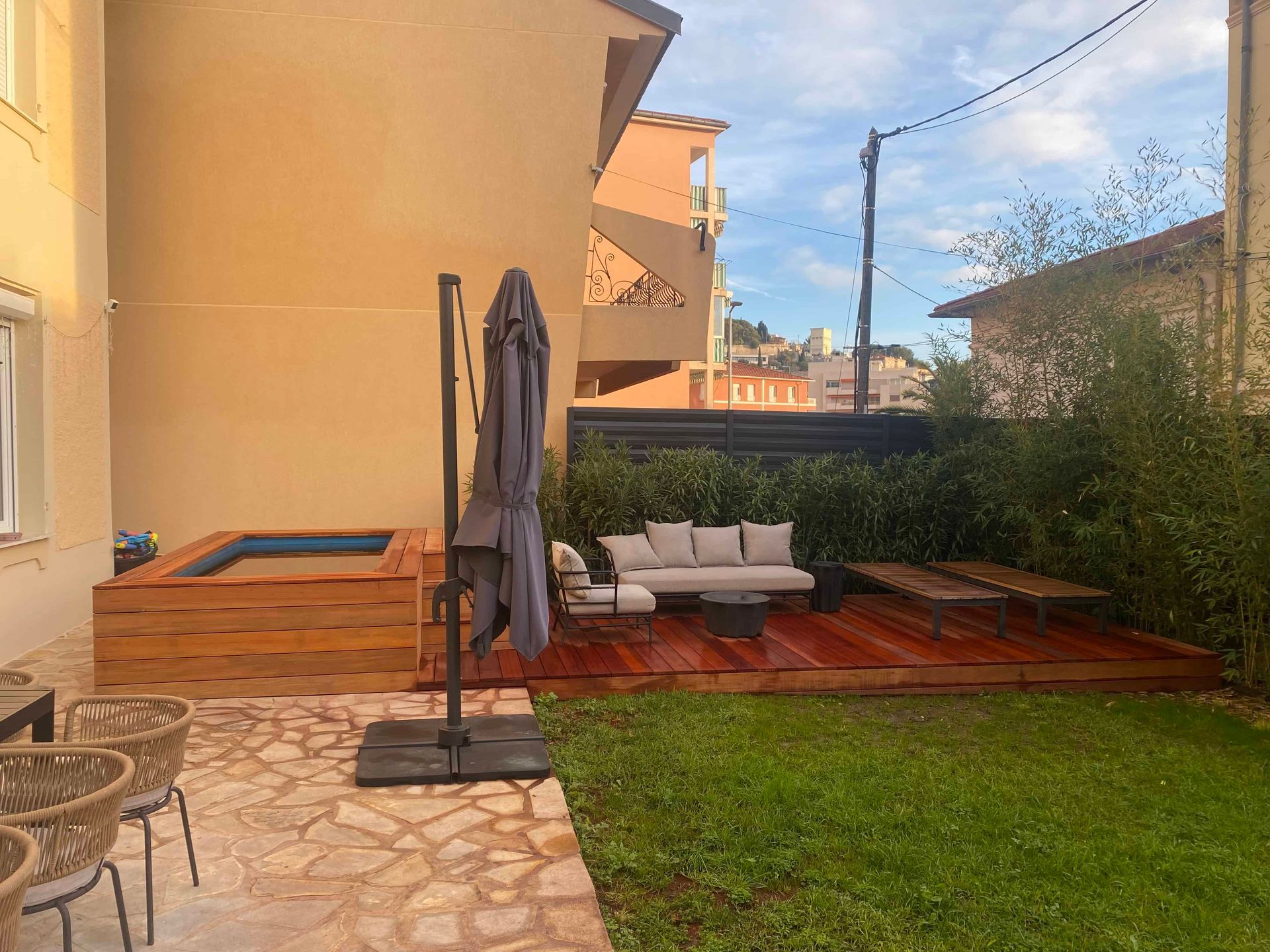 Il y a une terrasse en bois avec un canapé et des chaises dans la cour.