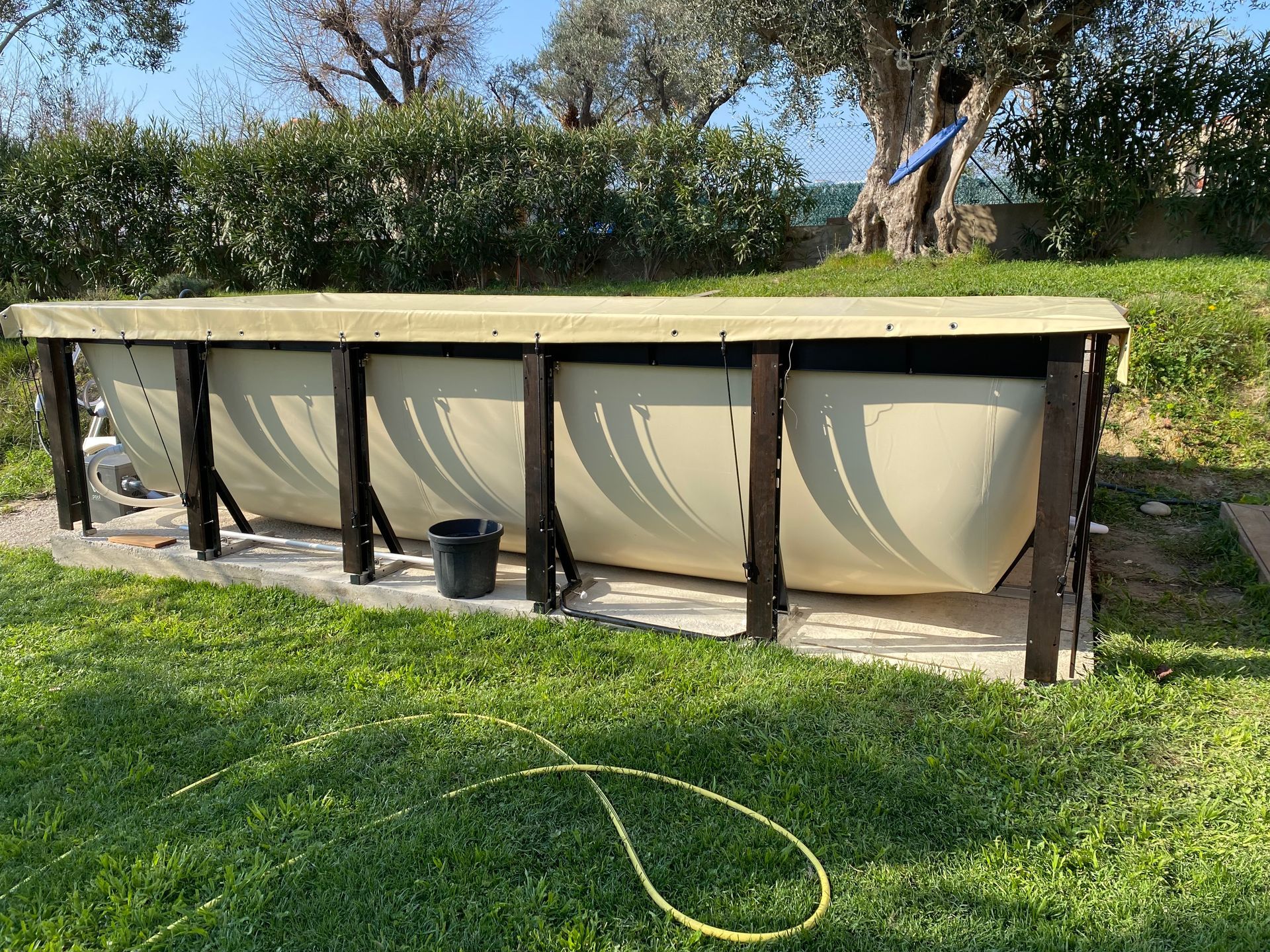 Une grande piscine se trouve au milieu d’un champ verdoyant.