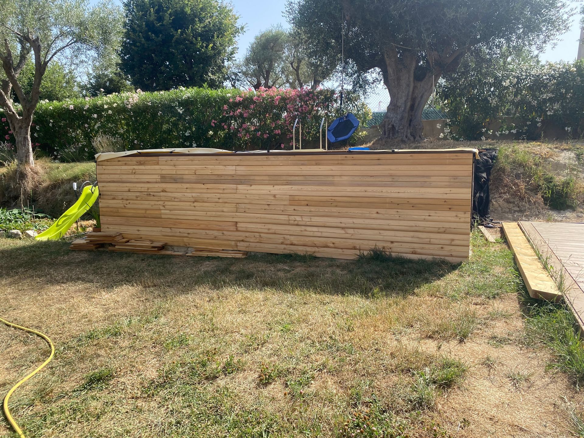 Une piscine en bois est en cours de construction dans une cour.