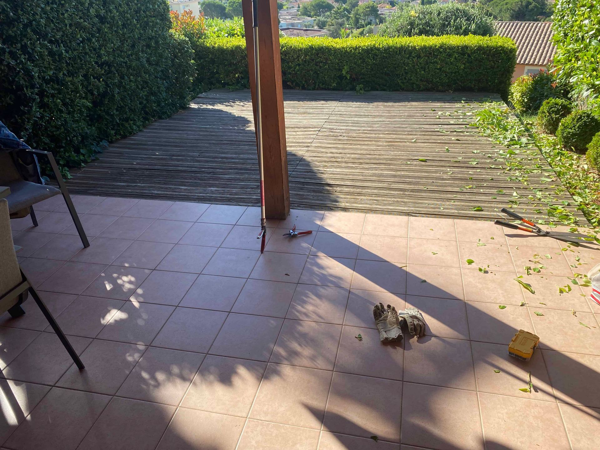 Un chien est allongé sur un sol carrelé sur une terrasse.