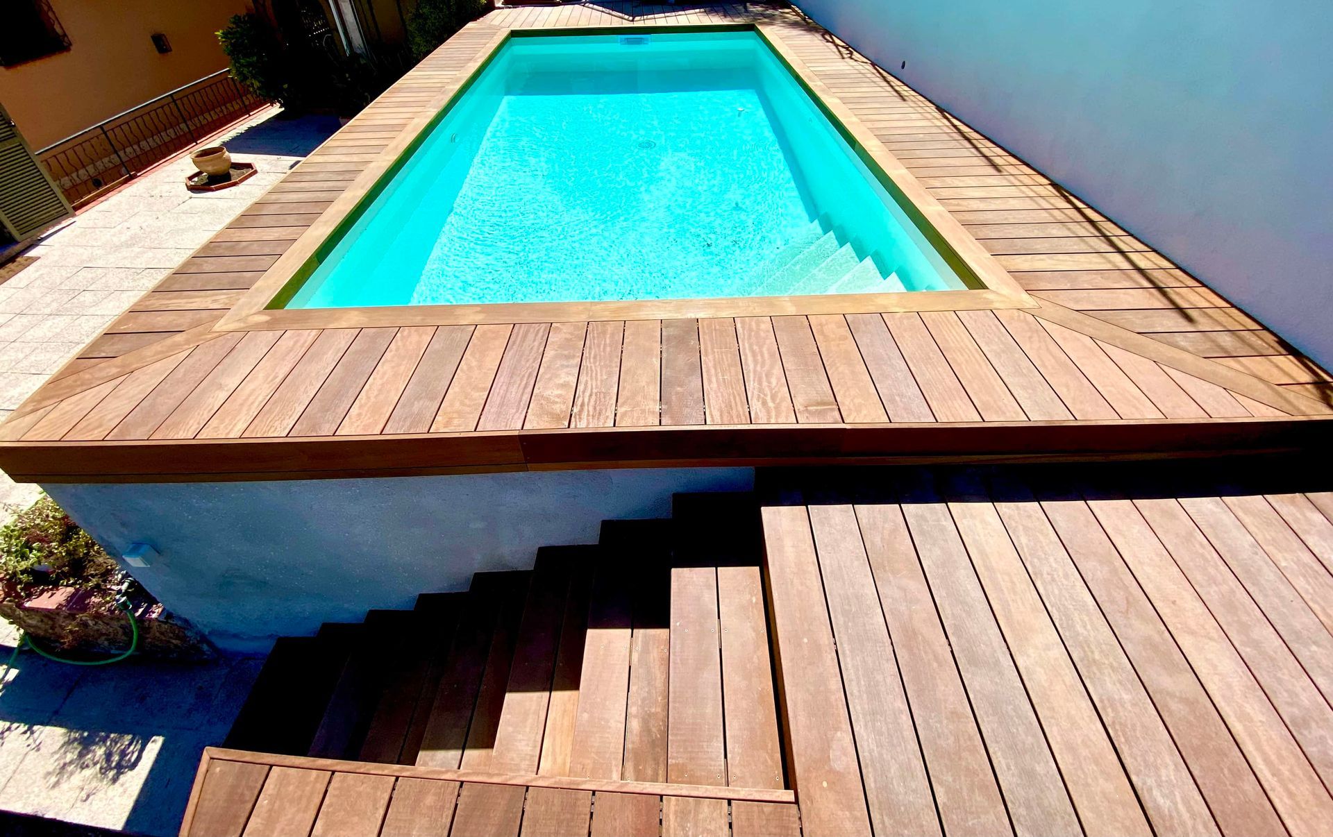Une piscine avec des escaliers qui y mènentTerrasse bois exotique et habillage piscine en bois ITAUBA avec fixations invisibles 