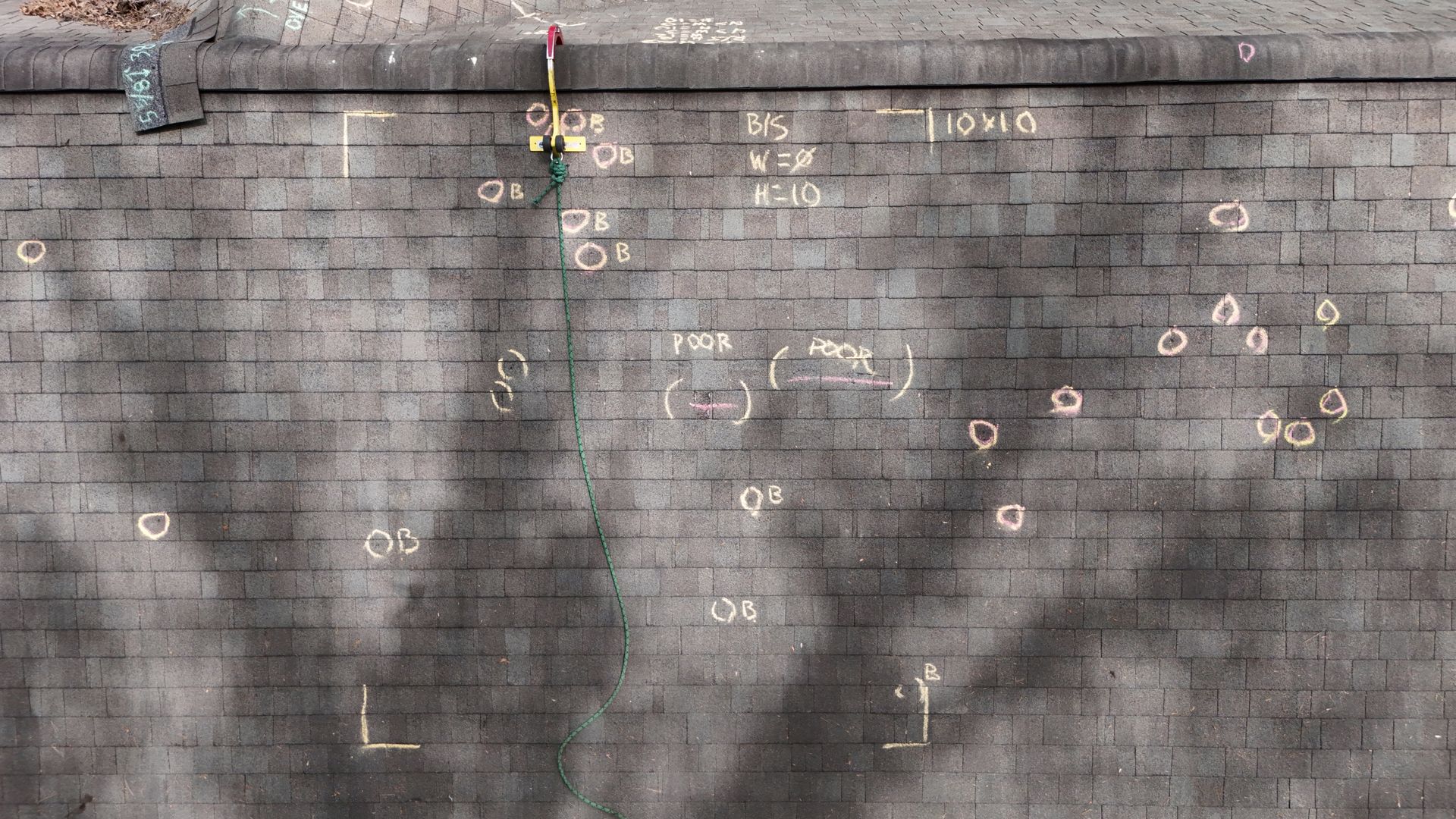 Weathered concrete wall with scattered chalk marks and faint graffiti lines.