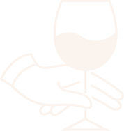 A hand is holding a glass of wine.