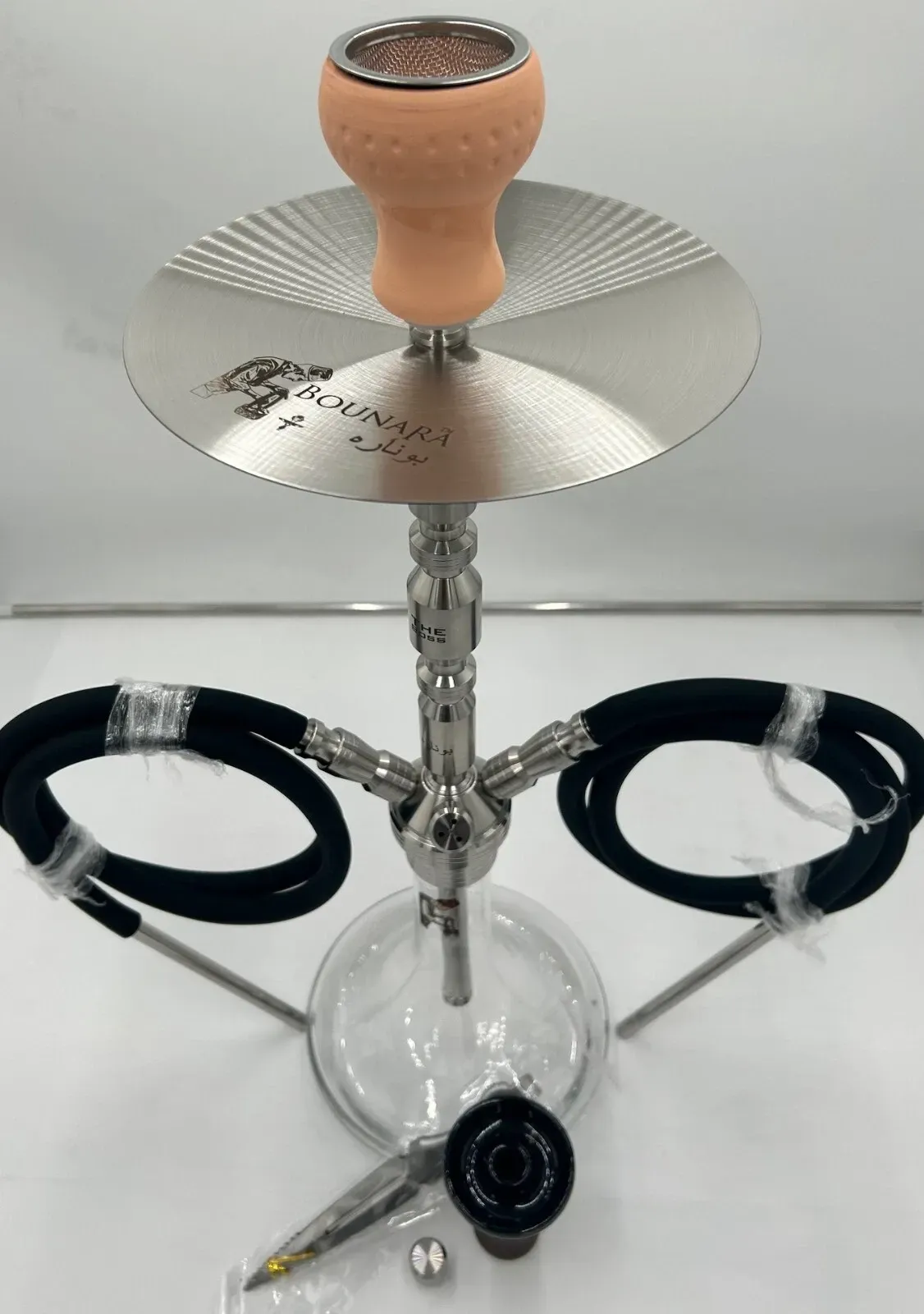 A hookah with a light brown bowl, silver metal stem, clear glass base, and two black hoses.
