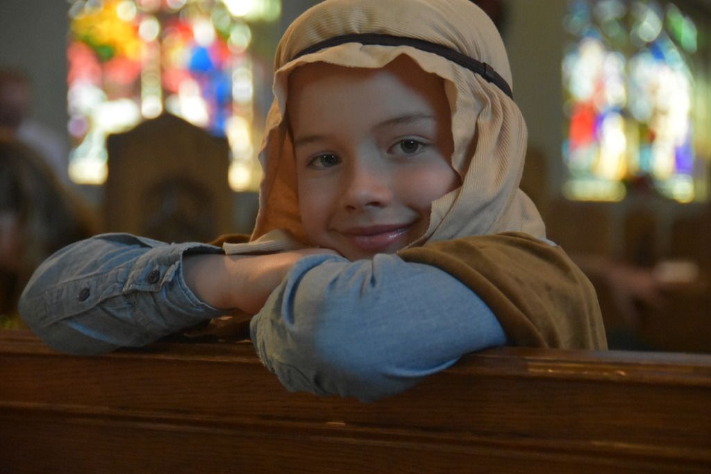 child dressed up like a shepherd sitting in church pew