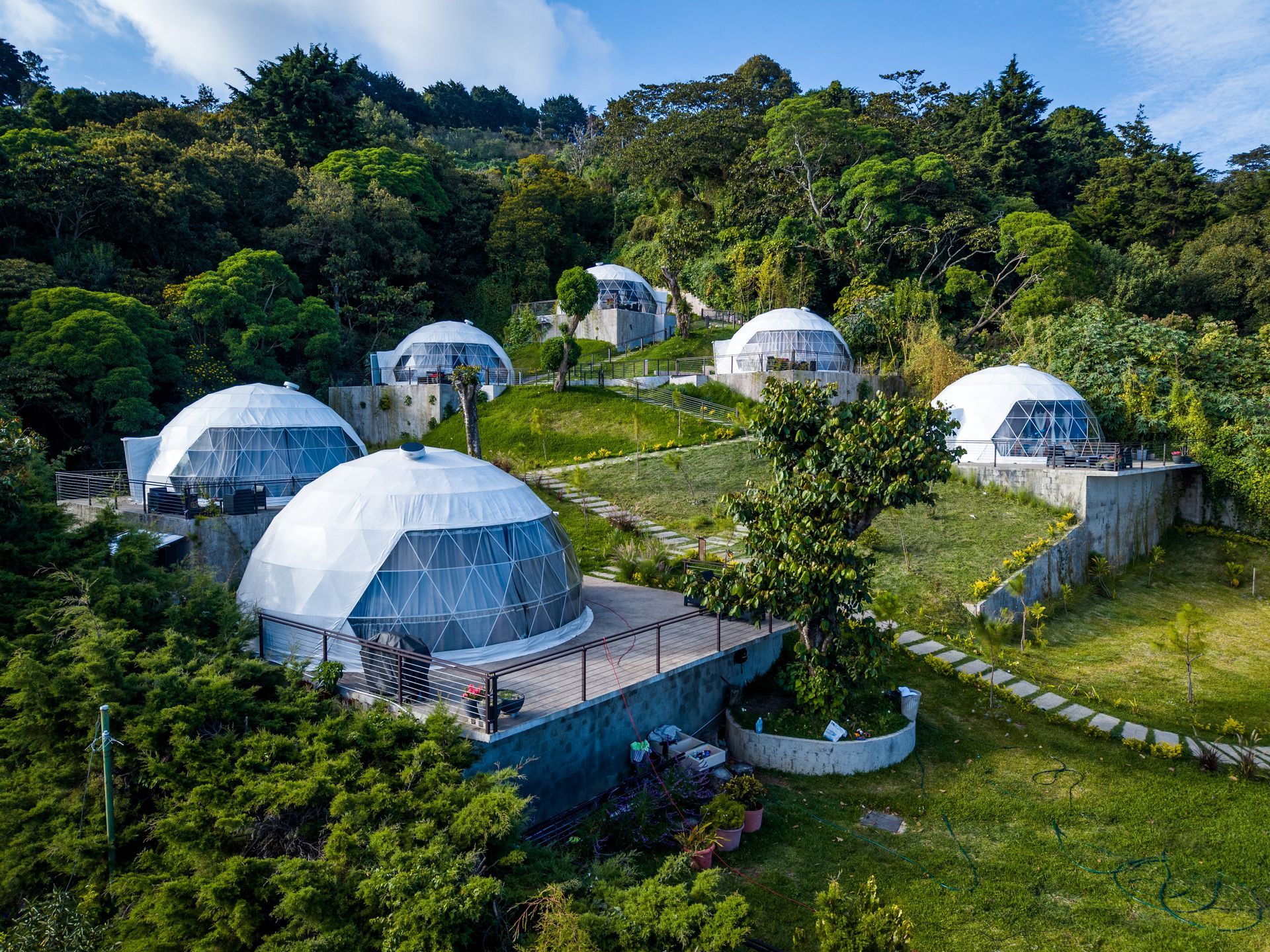 Cabañas de glamping con forma de cúpula blanca enclavadas en exuberantes colinas verdes en un soleado complejo turístico de montaña en el boquerón Cardedeu