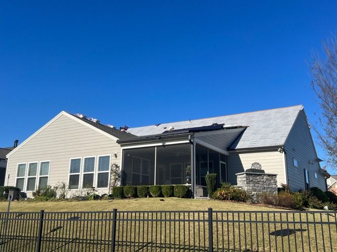 Single-story beige house with white trim and a screened porch under a clear blue sky