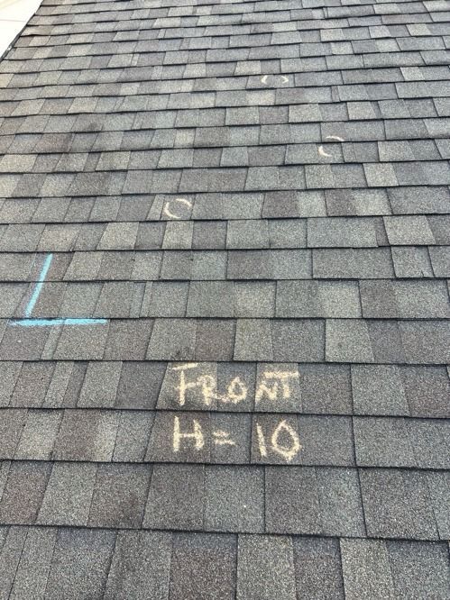 Roof shingles with chalk markings reading “Front H=10” and a blue L-shaped mark.