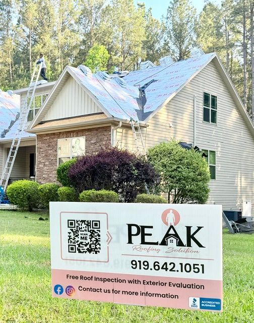 House with PEAK roofing sign in front, showing QR code, phone number, and contact info.