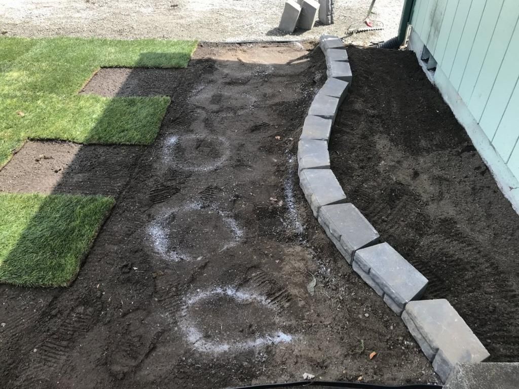 A concrete curb is being built next to a lawn.