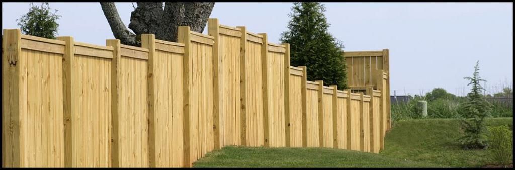 A wooden fence with a tree in the background