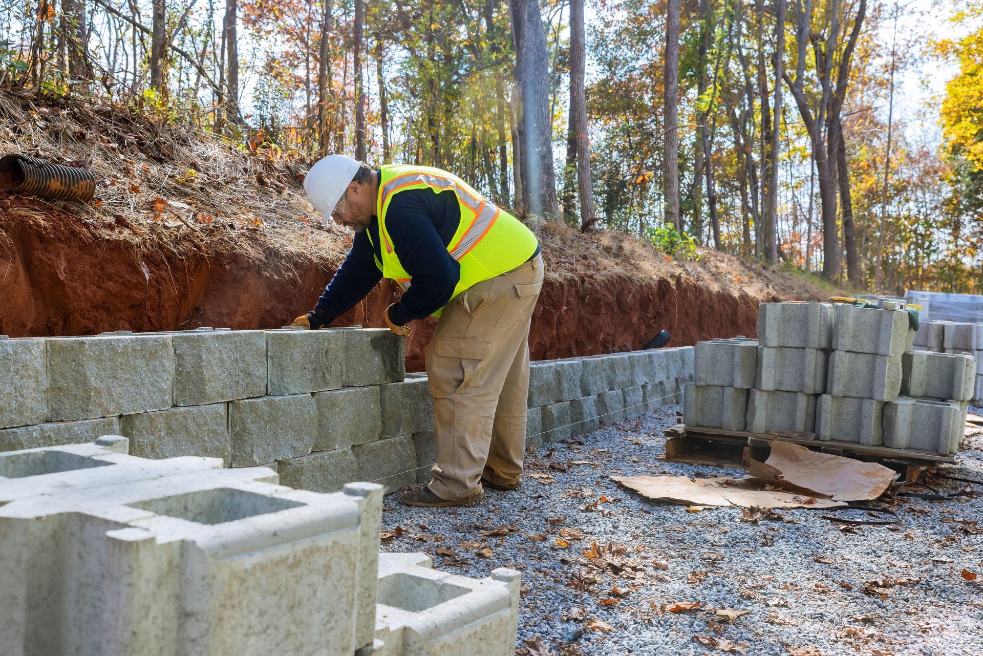 A construction worker is working on a concrete wall.