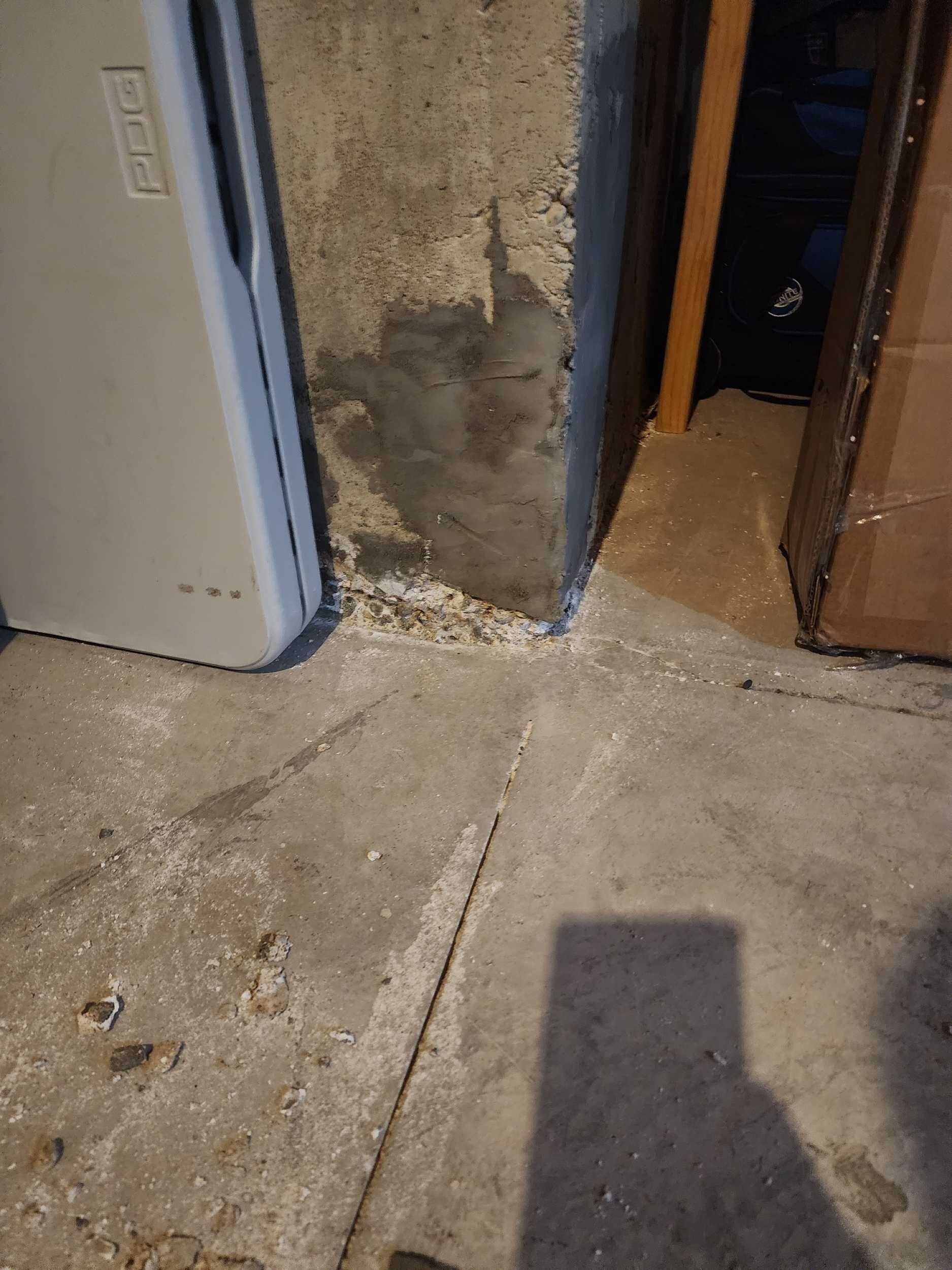 Damaged interior wall and doorway with peeling plaster and debris on the floor