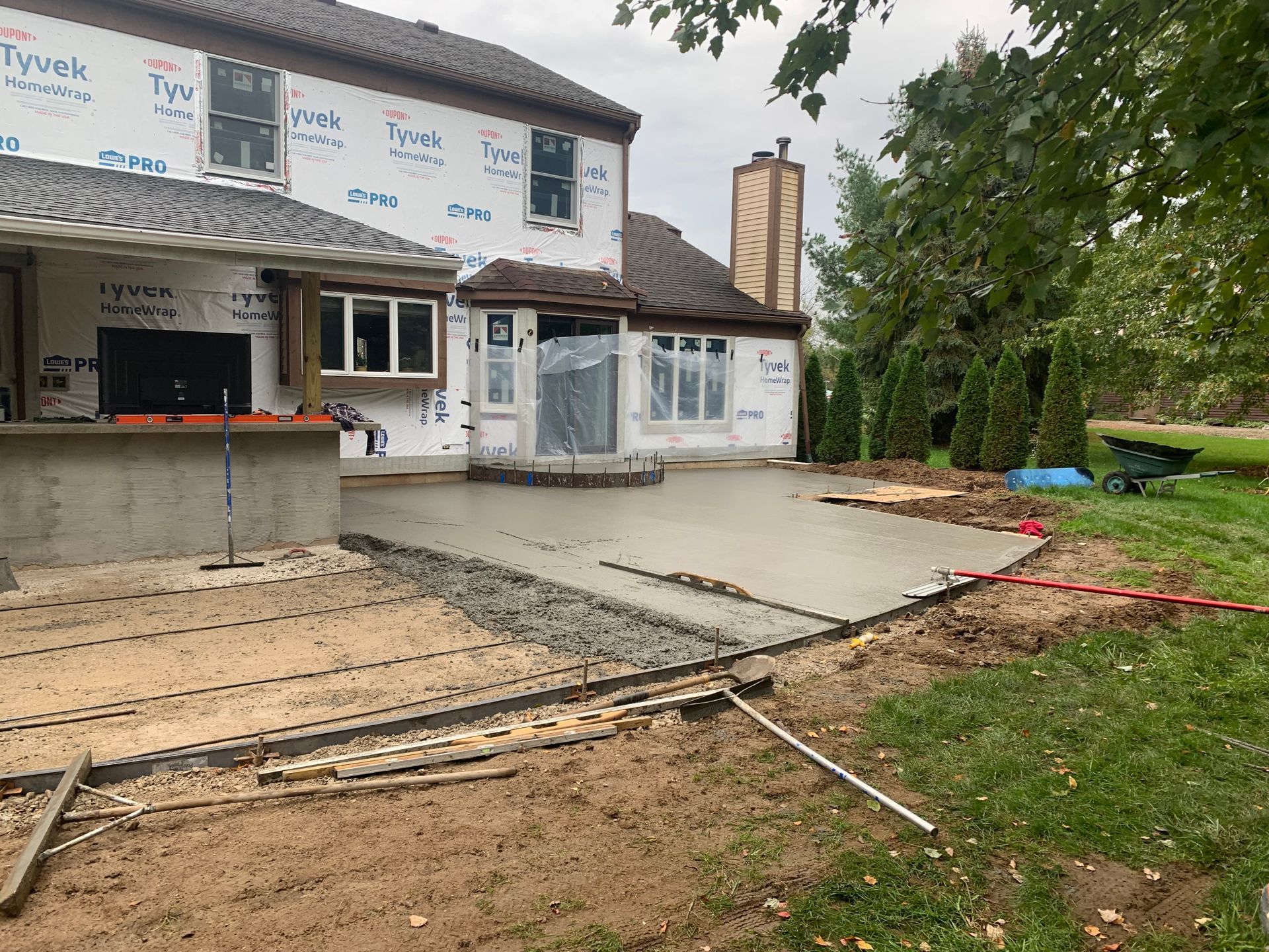House exterior with a newly poured concrete patio and unfinished landscaping work