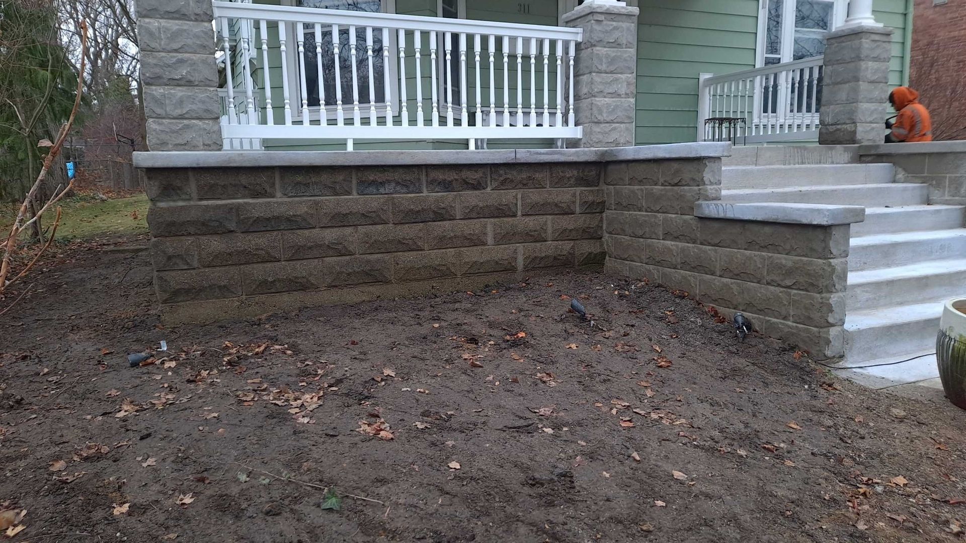 Front yard with broad brick steps and white porch railing leading to a home