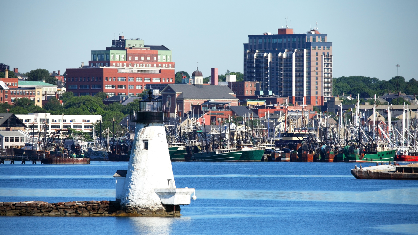 A lighthouse in the middle of a body of water with a city in the background