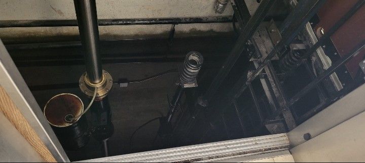 Industrial ceiling with exposed pipes, vents, and wiring in a dark maintenance space