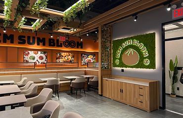Modern restaurant interior with orange sign, wooden counter, and green wall decor