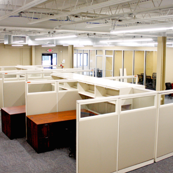 A large office with cubicles and desks in it