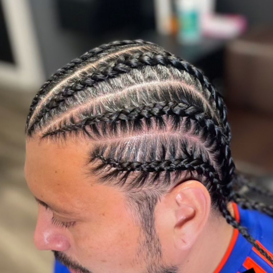 A woman with braids in her hair is wearing a black shirt.