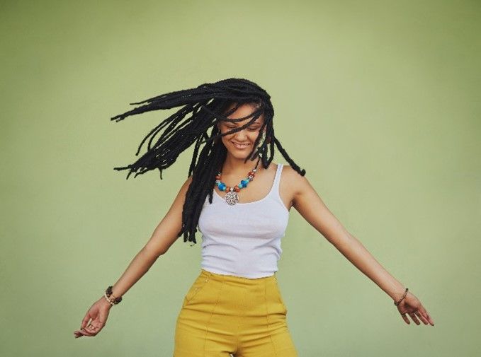 Black woman smiling and playing with her braids, showcasing beautiful hair braids style, radiating joy and confidence in her look Black woman smiling and playing with her braids, showcasing beautiful hair braids style, radiating joy and confidence in her look