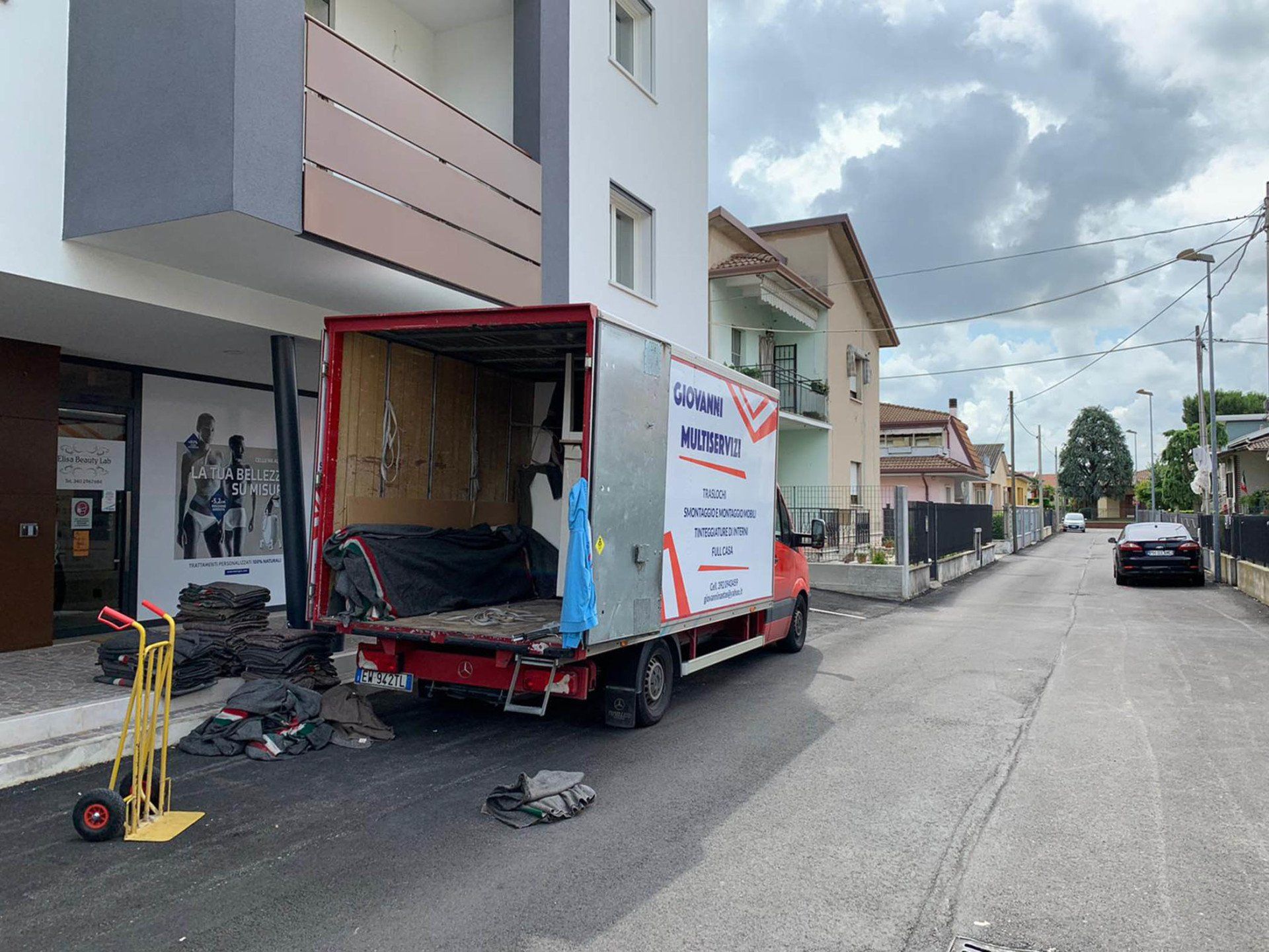 Lastre di vetro verticali di diverse altezze sono disposte in fila sotto un soffitto di lamiera ondulata.