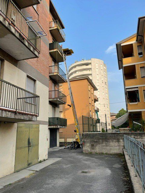 Lastre di vetro verticali di diverse altezze sono disposte in fila sotto un soffitto di lamiera ondulata.