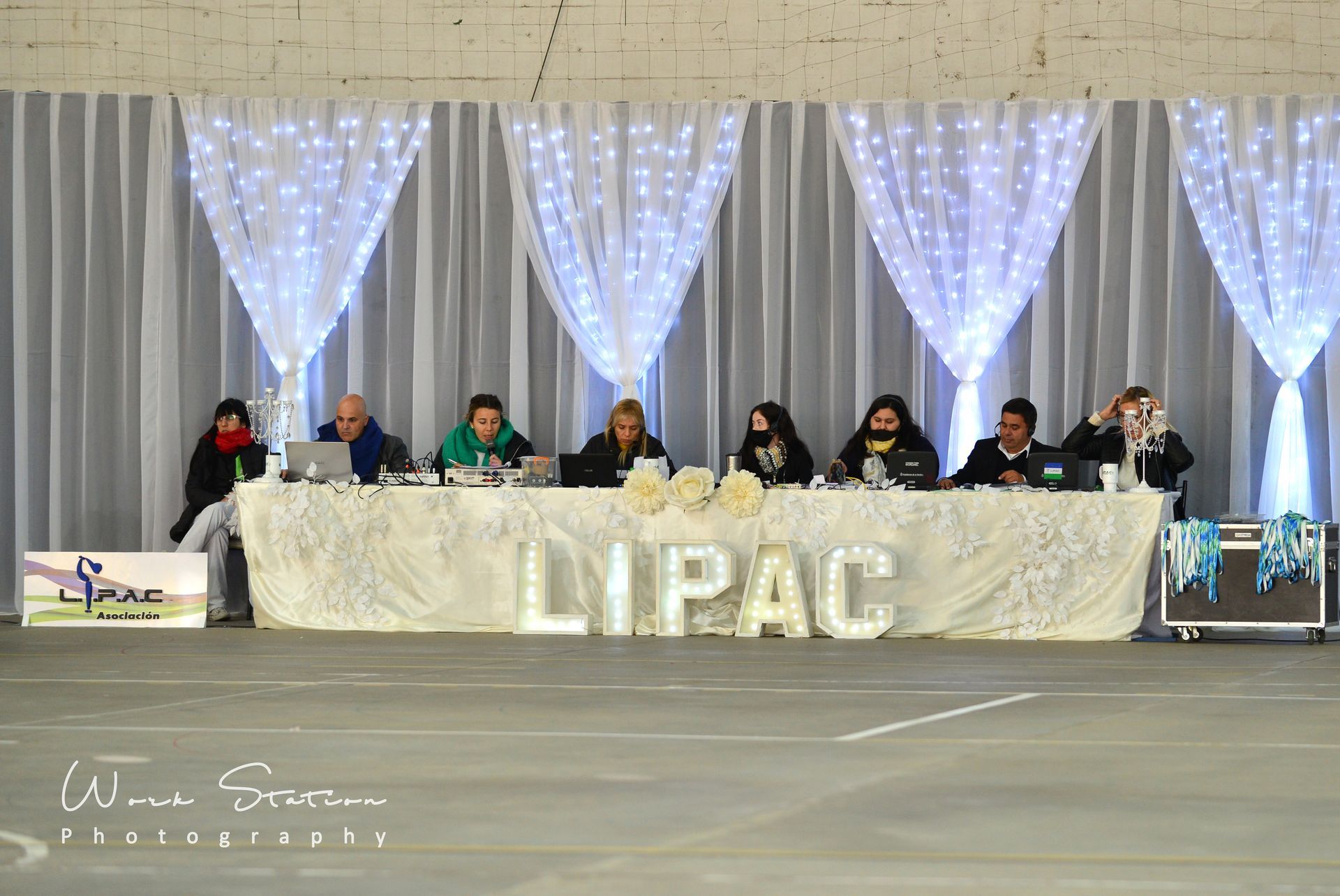 Una fila de personas sentadas detrás de una mesa larga con la etiqueta 
