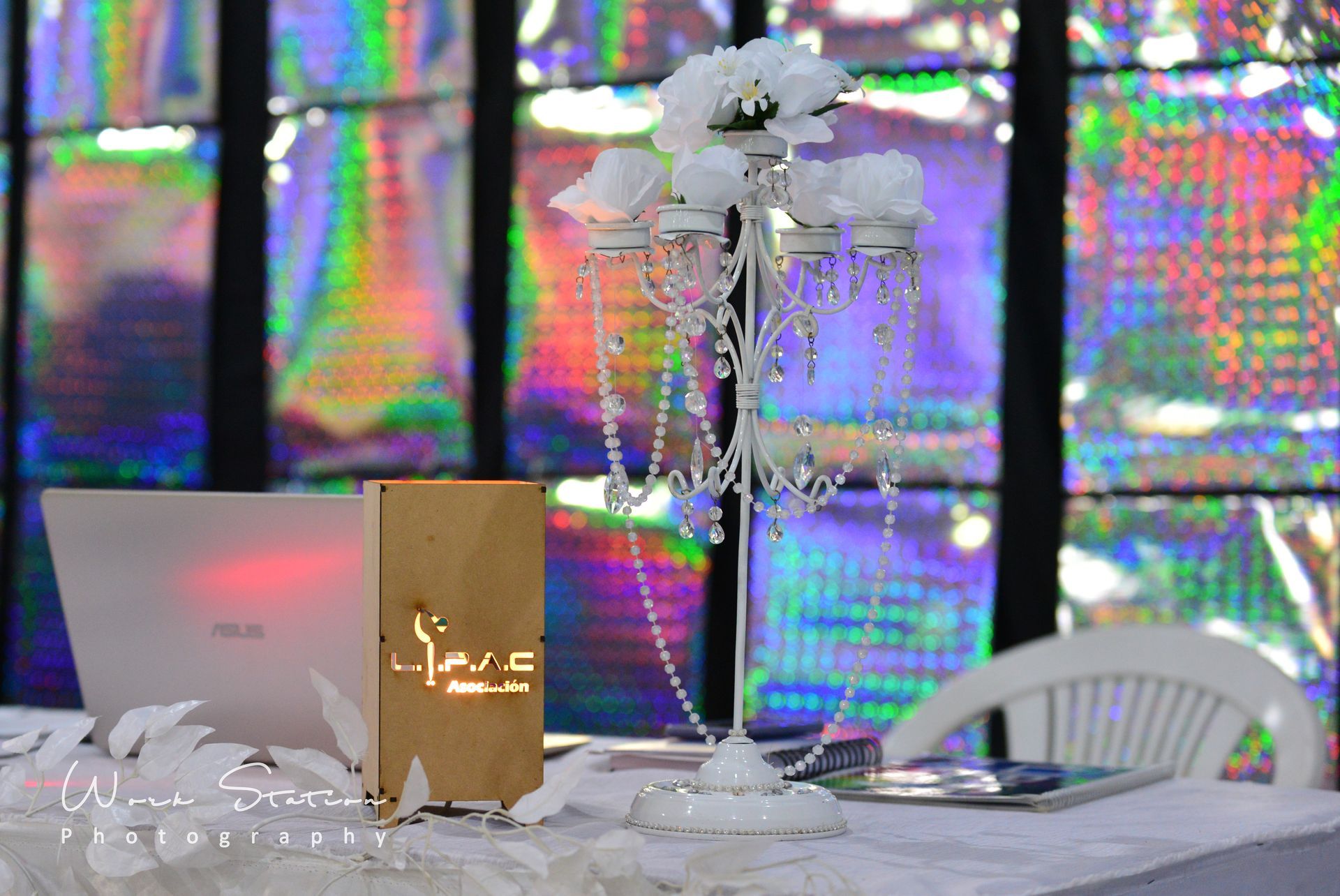 Un candelabro plateado como centro de mesa, una computadora portátil 