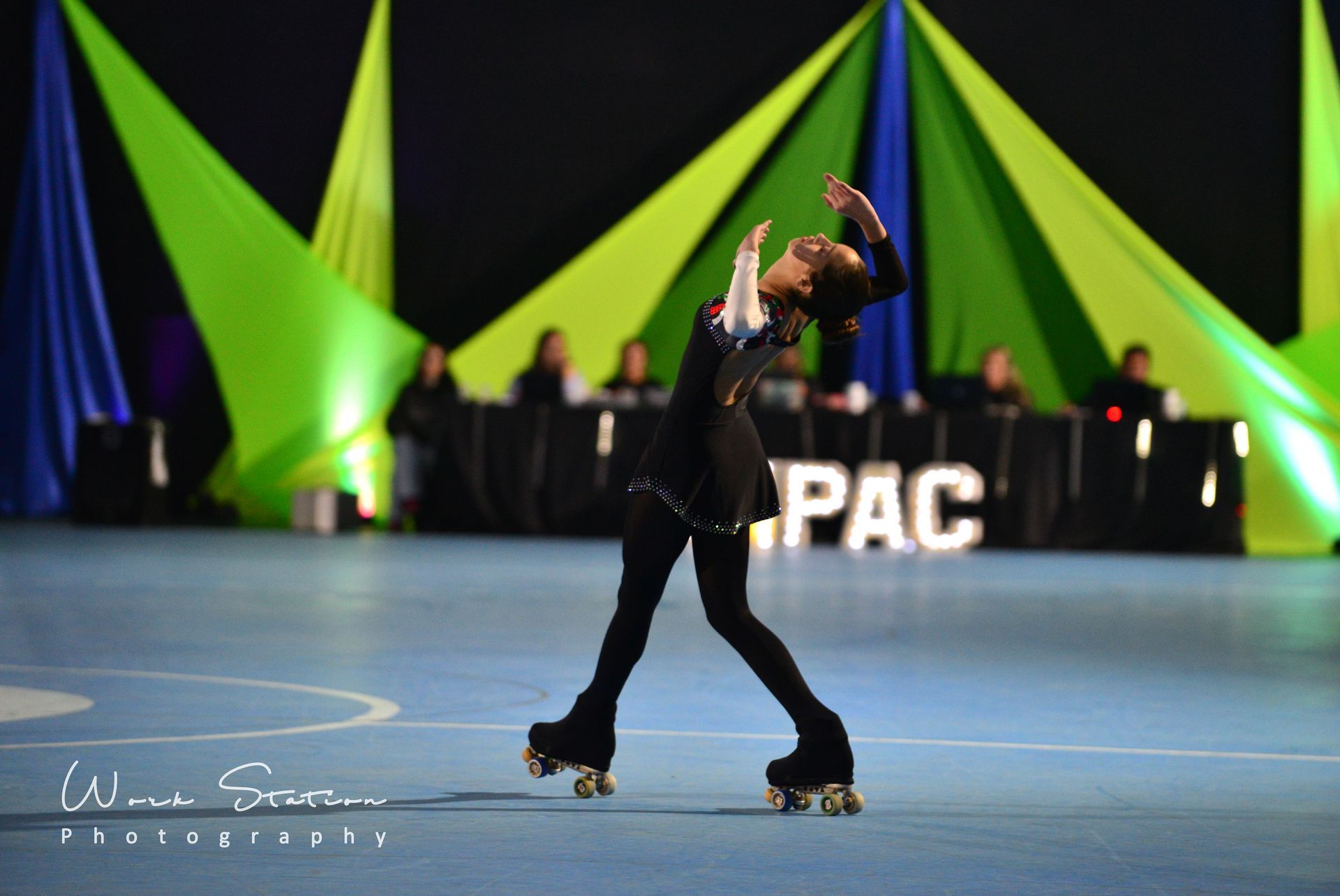 Una patinadora con un traje negro realiza una elegante 