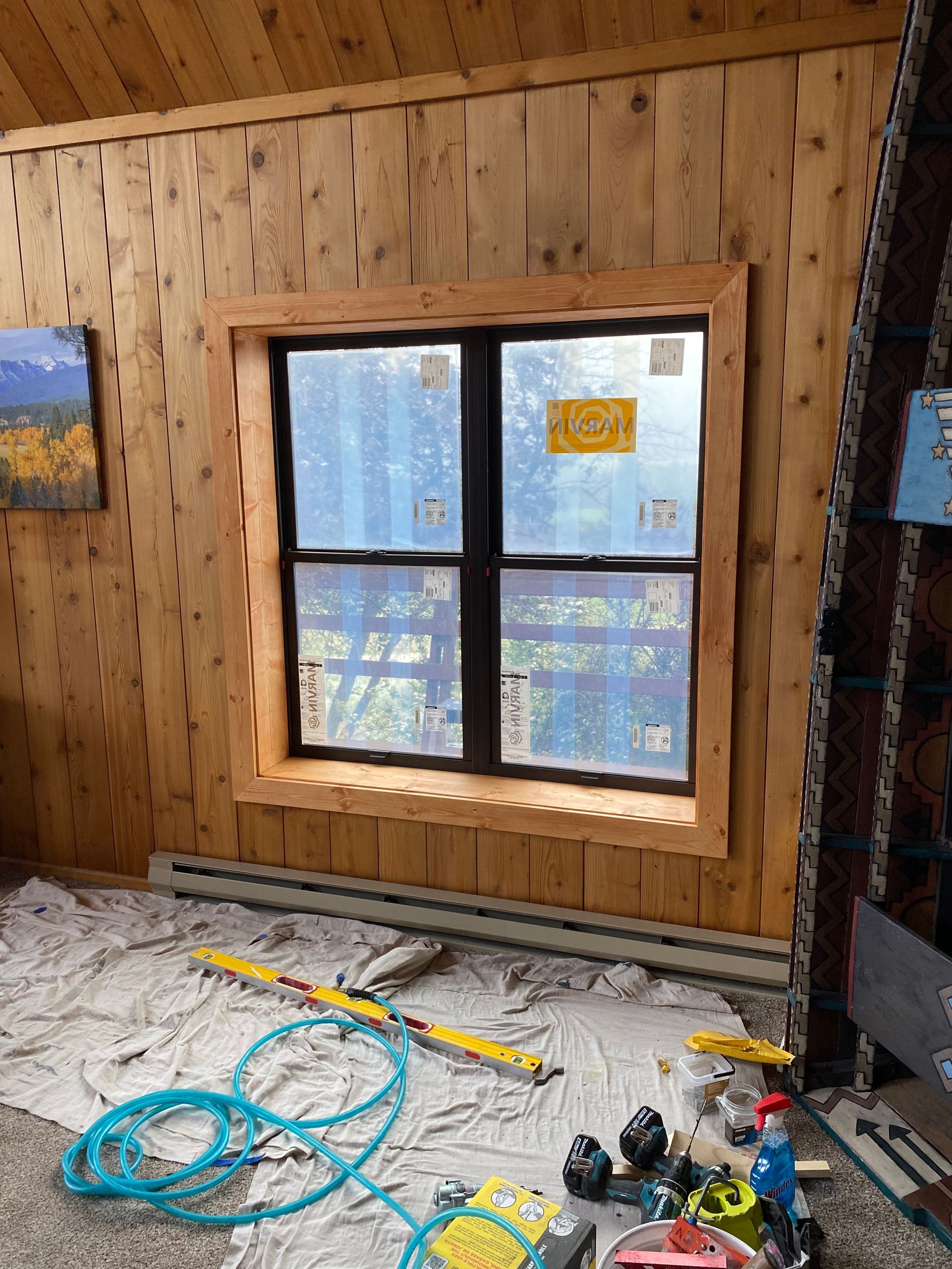 A room with a window and a lot of tools on the floor.