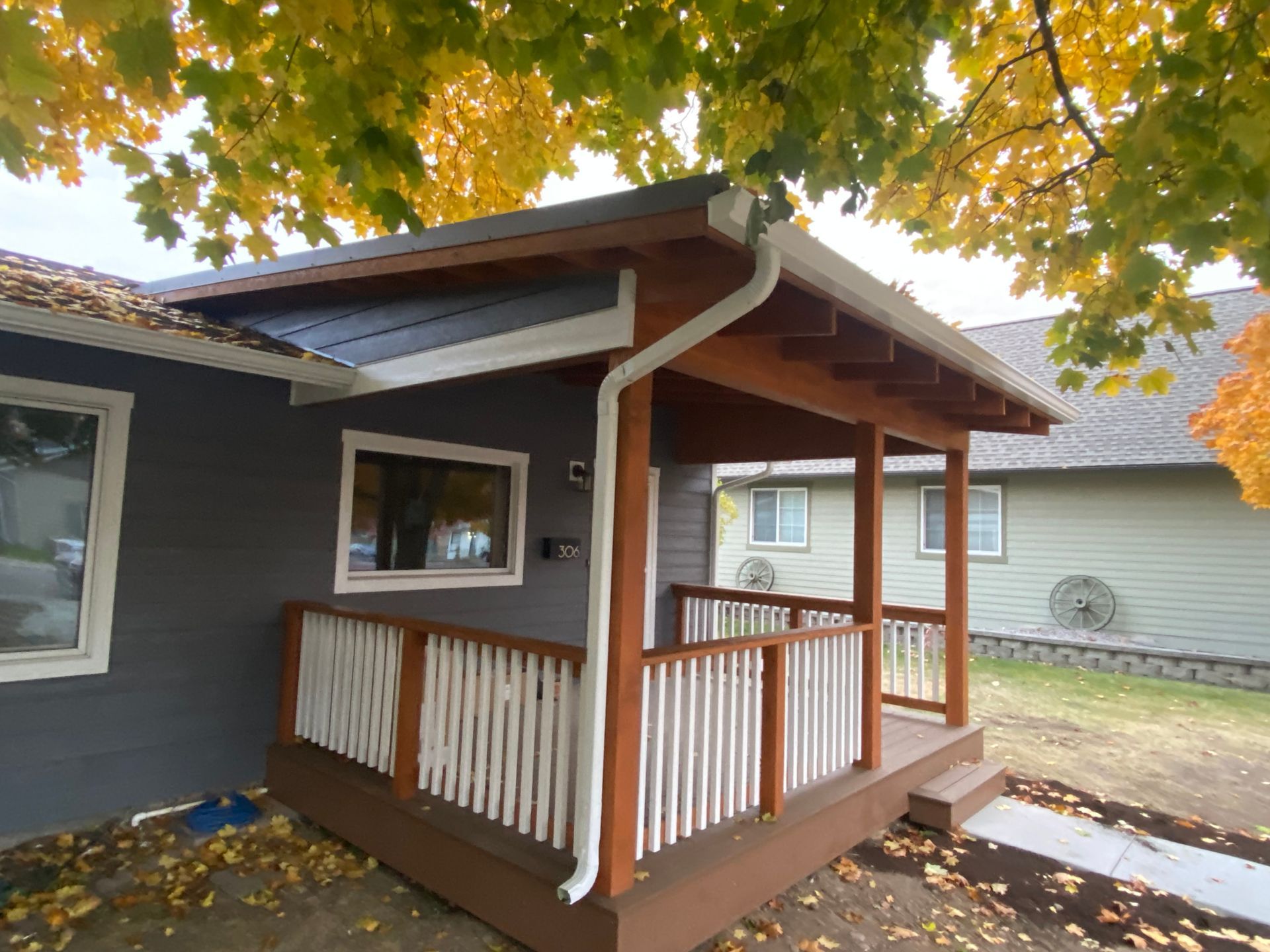 A house with a porch and a tree in the background