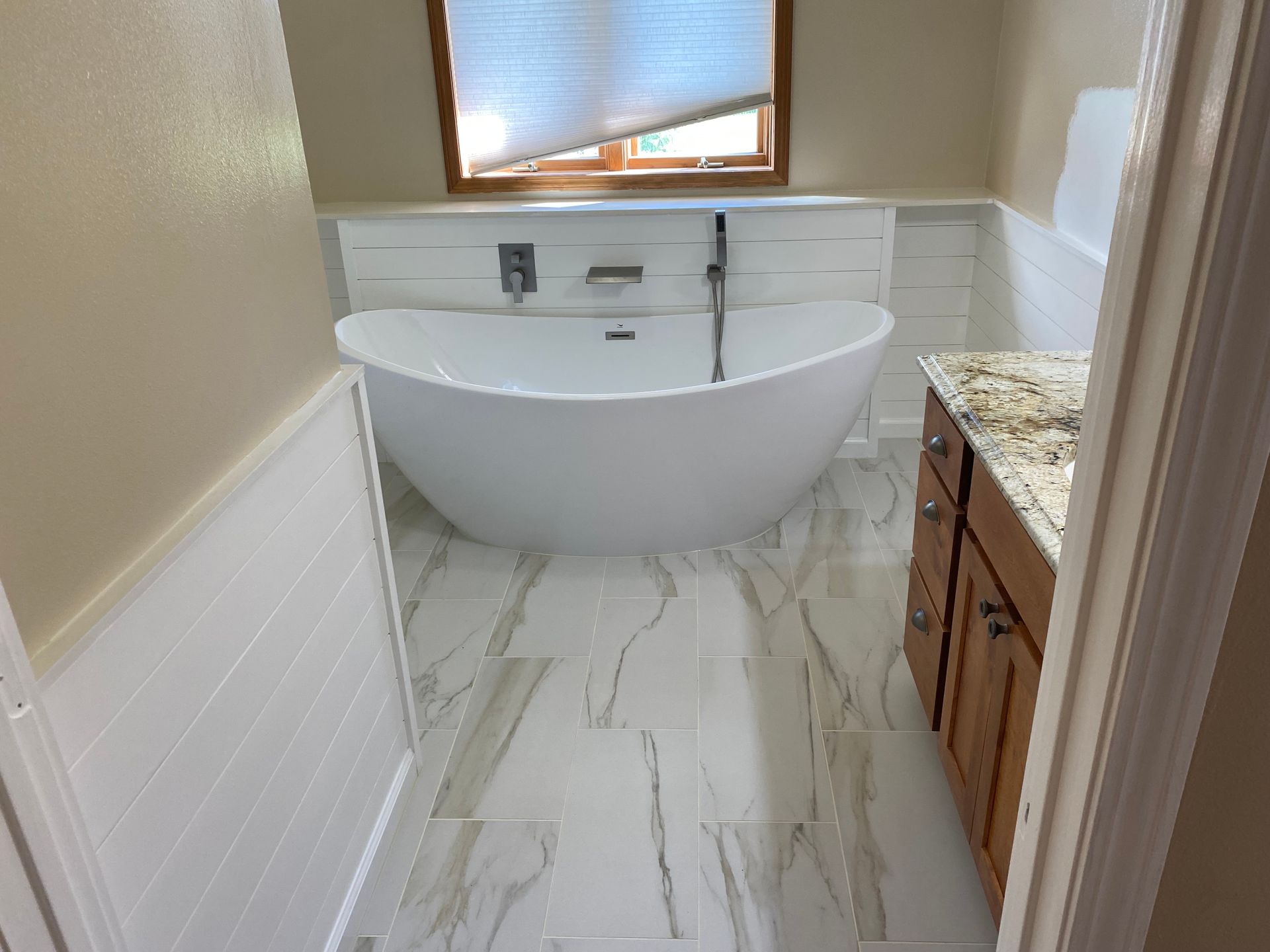 A bathroom with a bathtub and a window.