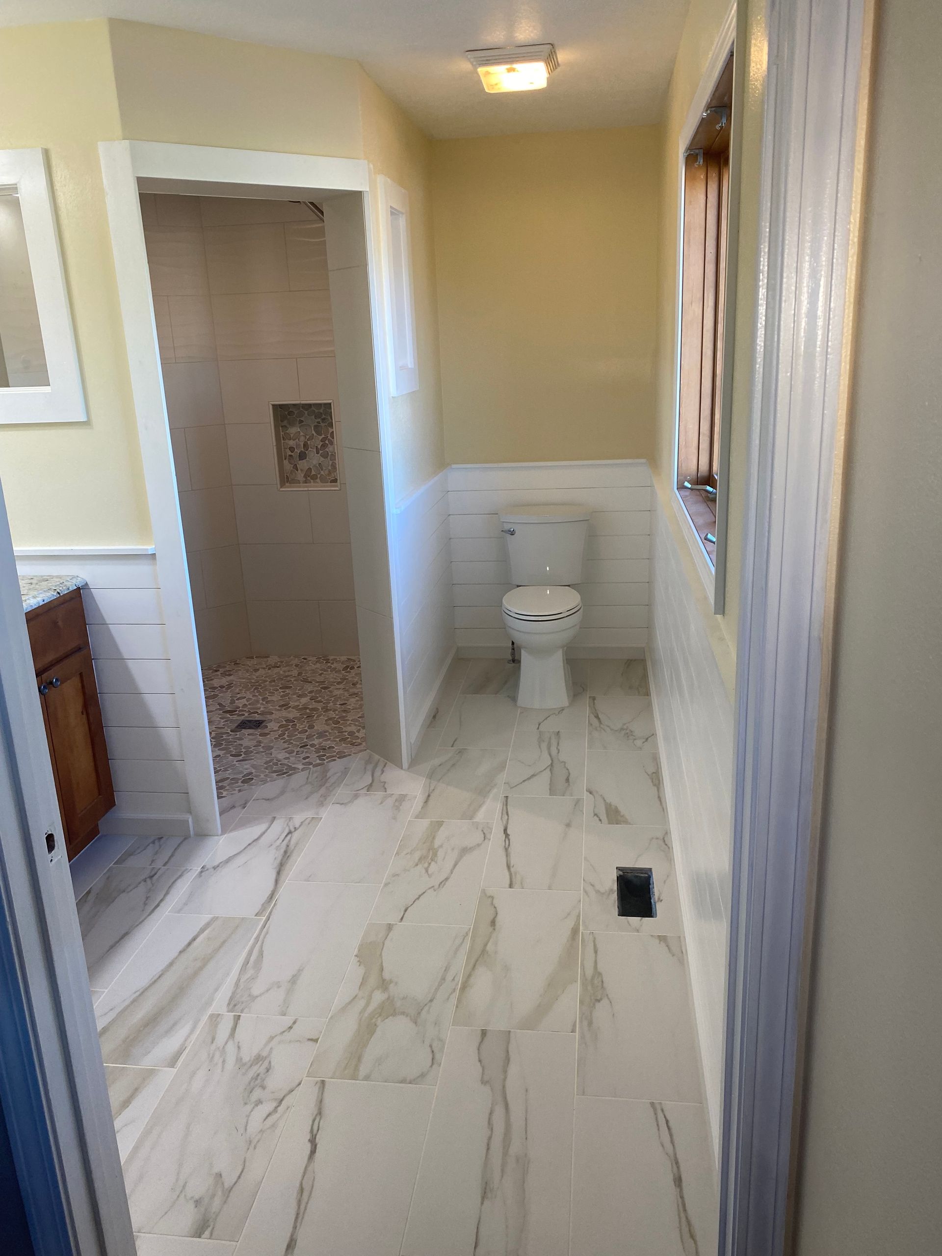 A bathroom with a toilet , sink , and shower.