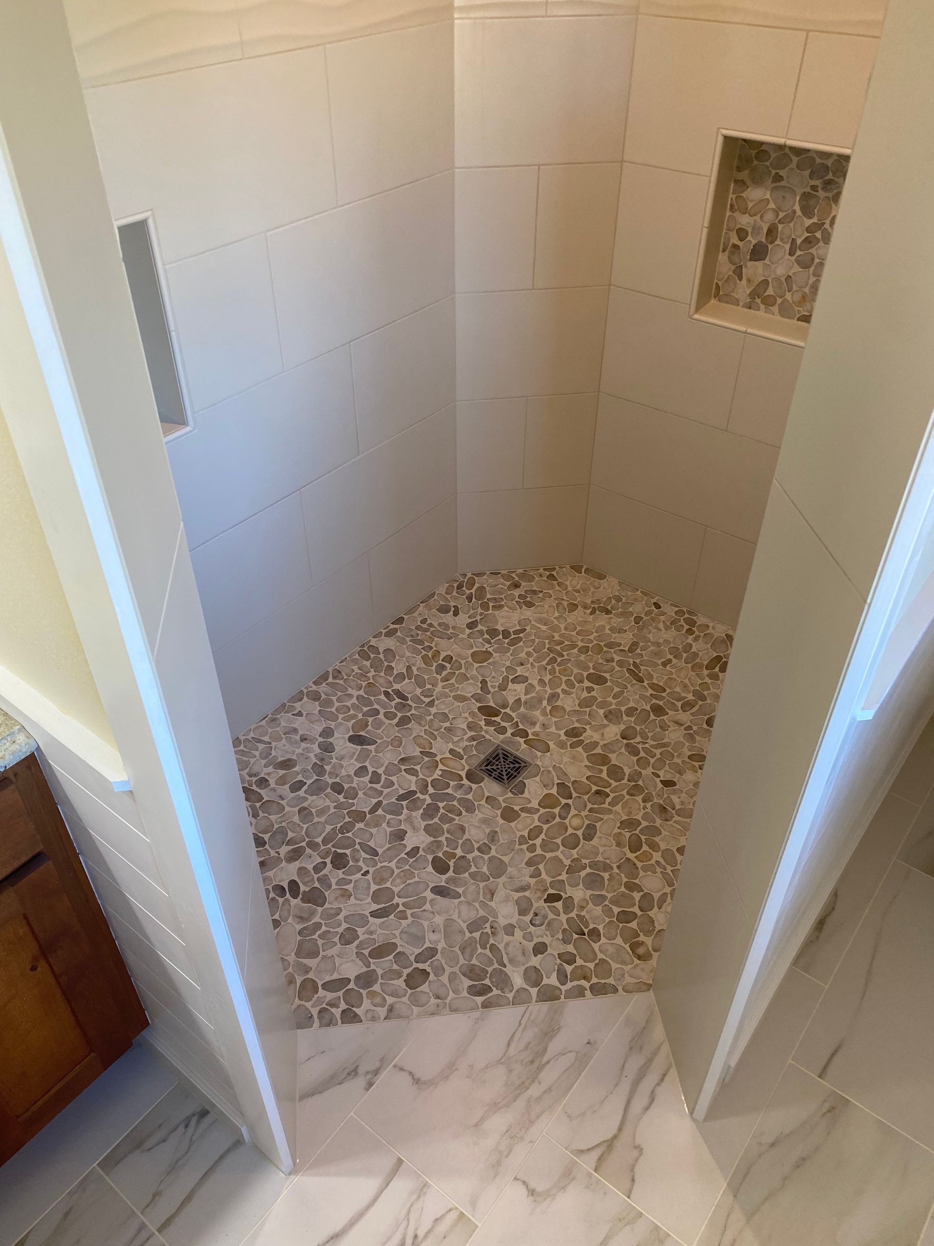A bathroom with a walk in shower and a sink.