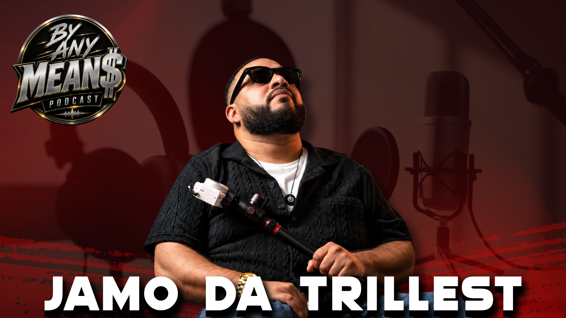 Man in sunglasses and black shirt posing against a red studio background with the text “JAMO DA TRILLEST”