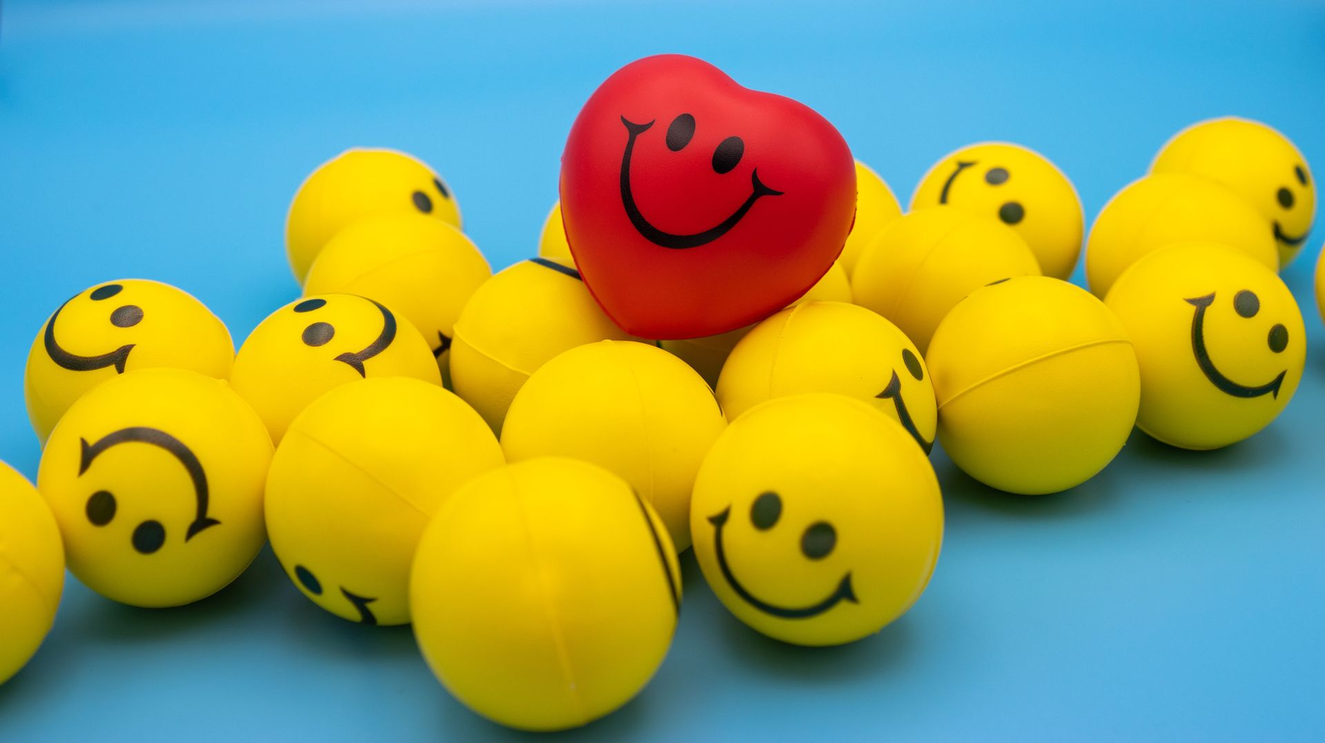 Smiling yellow and red balls arranged on a blue background