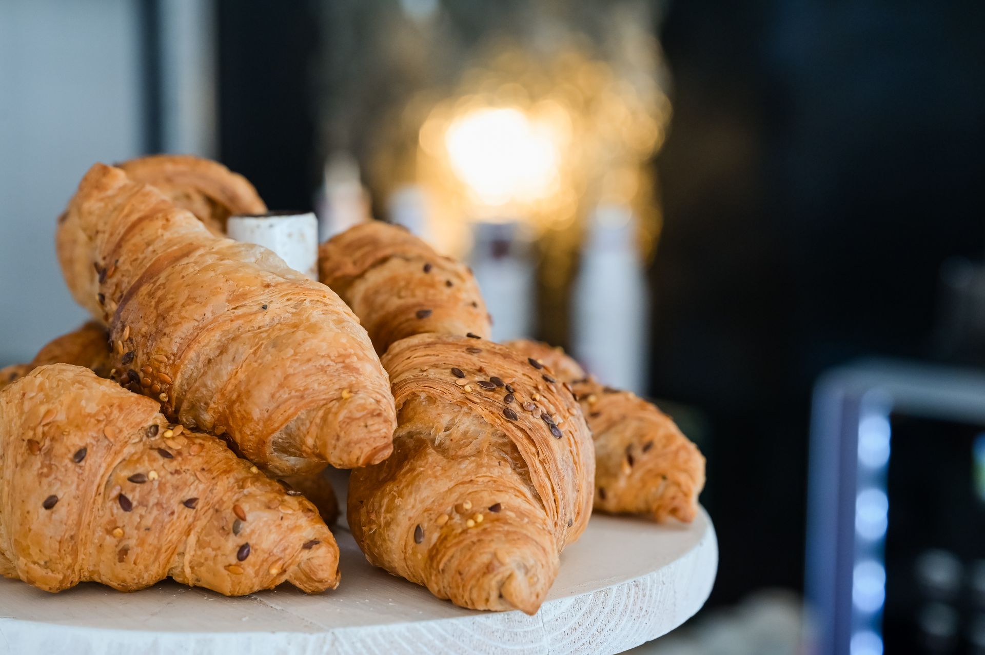 Cornetti su un'alzatina bianca con uno sfondo sfocato di un caffè.