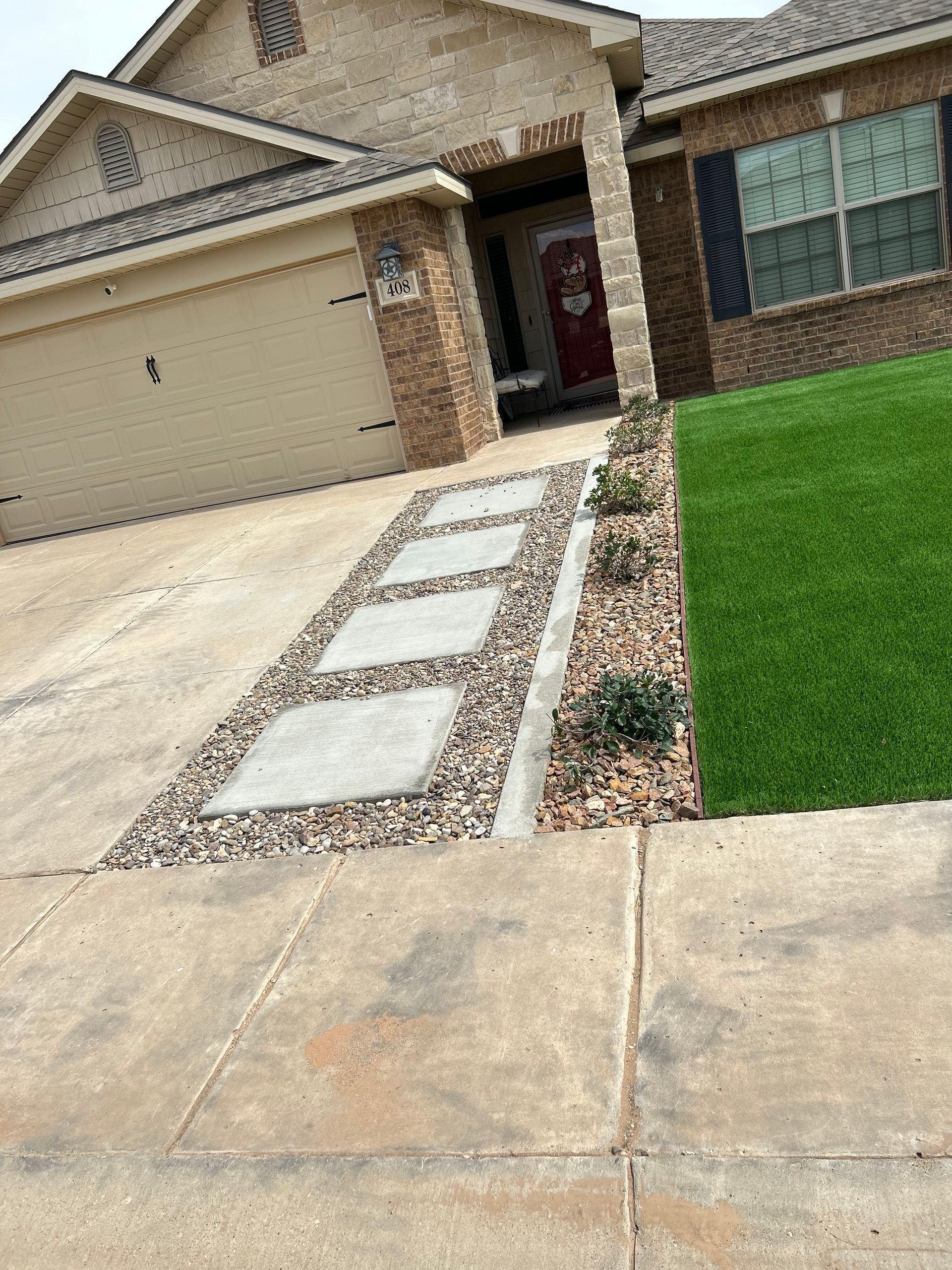Front yard walkway with square stepping stones leading to a suburban house entrance and garage.