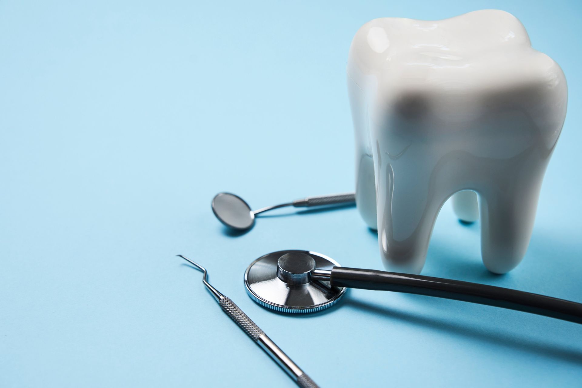 a tooth and dental instruments on a blue background .
