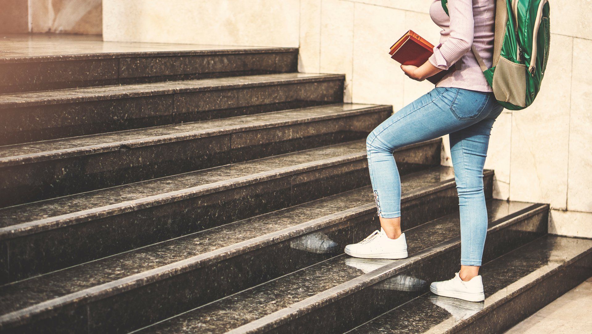 A girl college student walking up the staircase