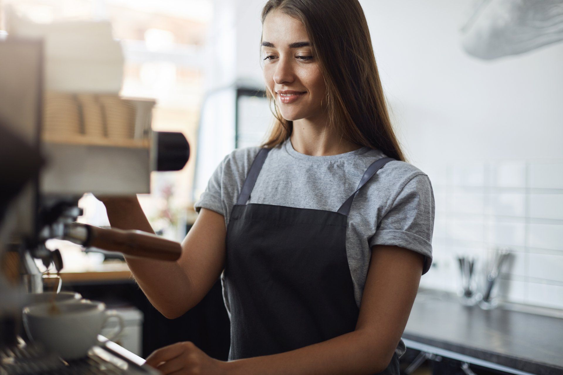 Female student on her summer job serving coffee working as a in a local pastry shop
