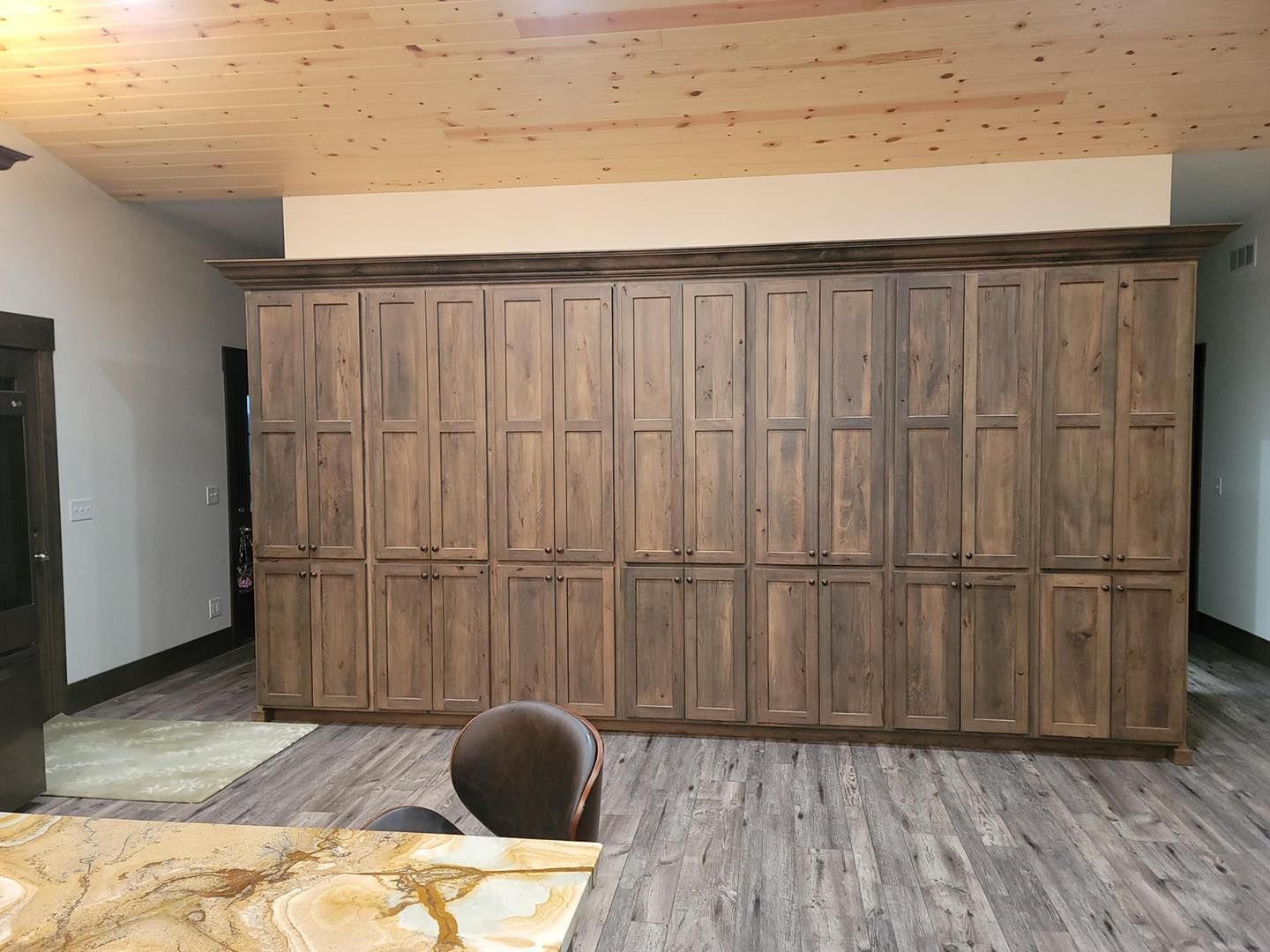A room with a lot of wooden cabinets and a wooden floor.