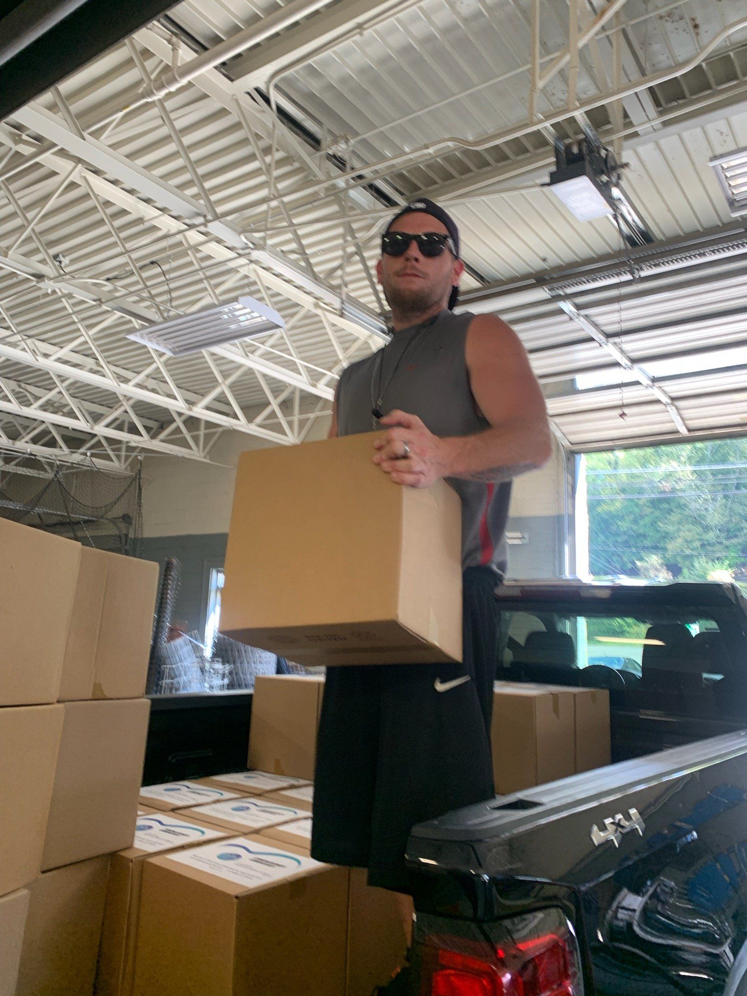 A man is carrying a box in the back of a truck.