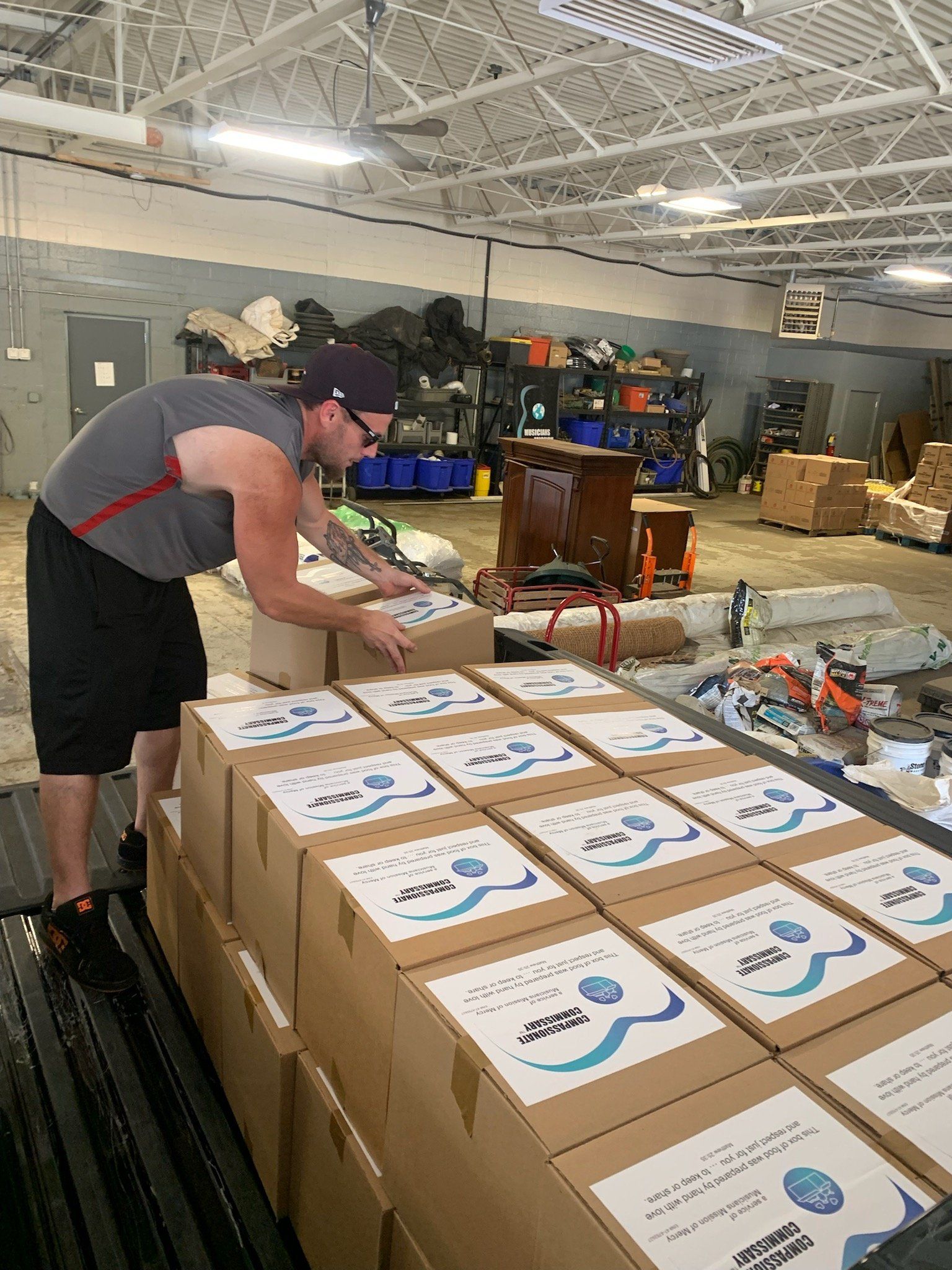 A man is packing boxes in a warehouse.