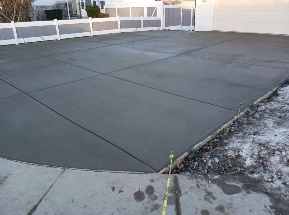 Concrete rooftop patio with expansion joints and a low wall in the background