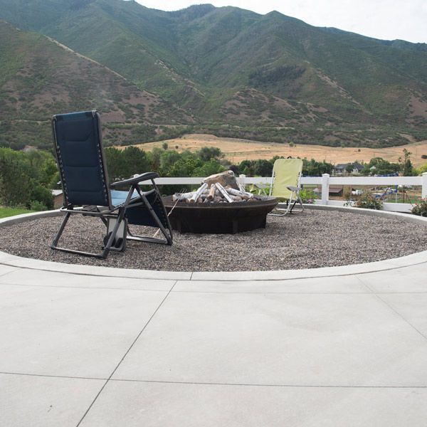 Patio fire pit with two folding chairs overlooking a mountainous landscape