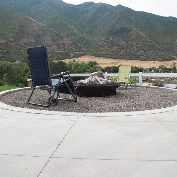 Patio fire pit with two lounge chairs overlooking a mountain valley