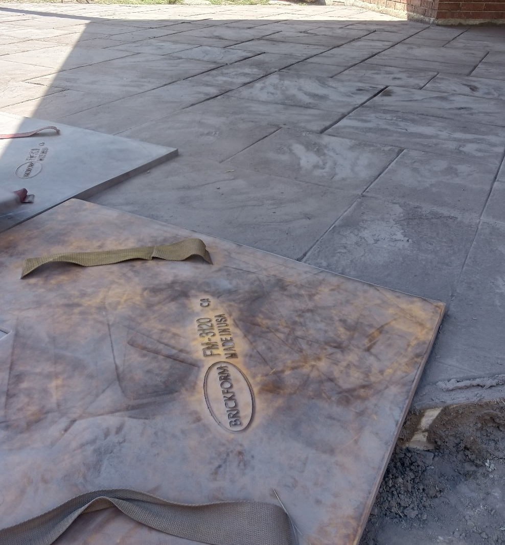 Large gray concrete slabs on a patio, with one slab showing a logo and yellow label.