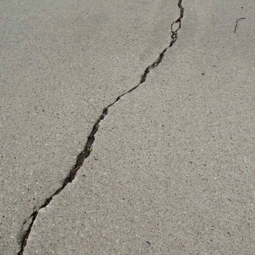 Cracked gray concrete surface with a long diagonal fracture